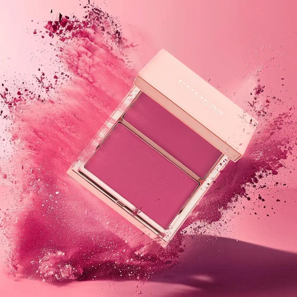 Compact blush duo with cream and powder textures in deep rose shades on pink background.