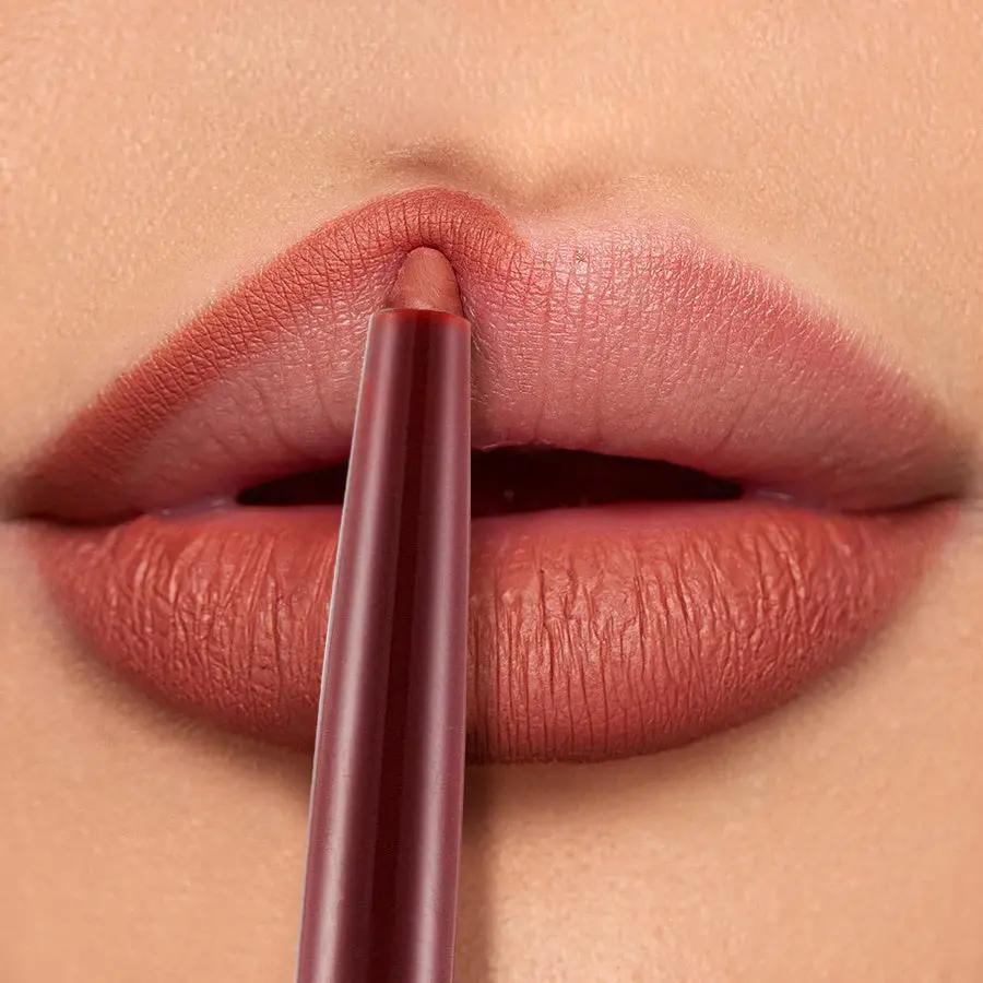 Matte terracotta lip liner pencil defining smooth, full lips with rich color.