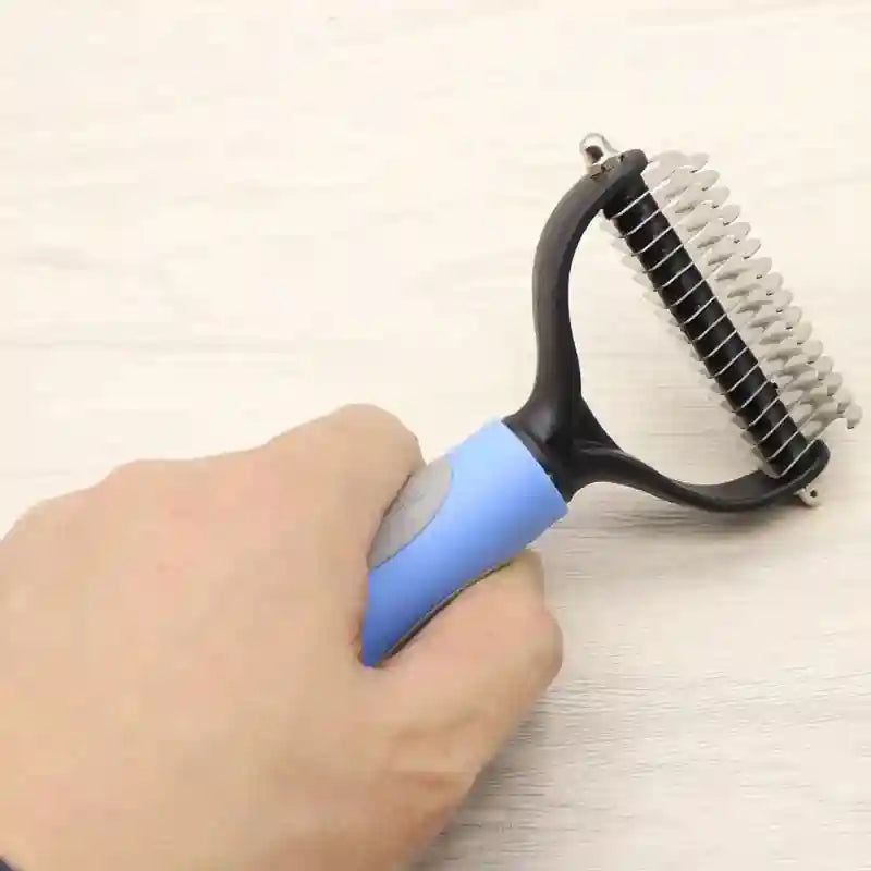 Double-sided dematting comb with blue handle and metal blades for long-haired dog grooming.